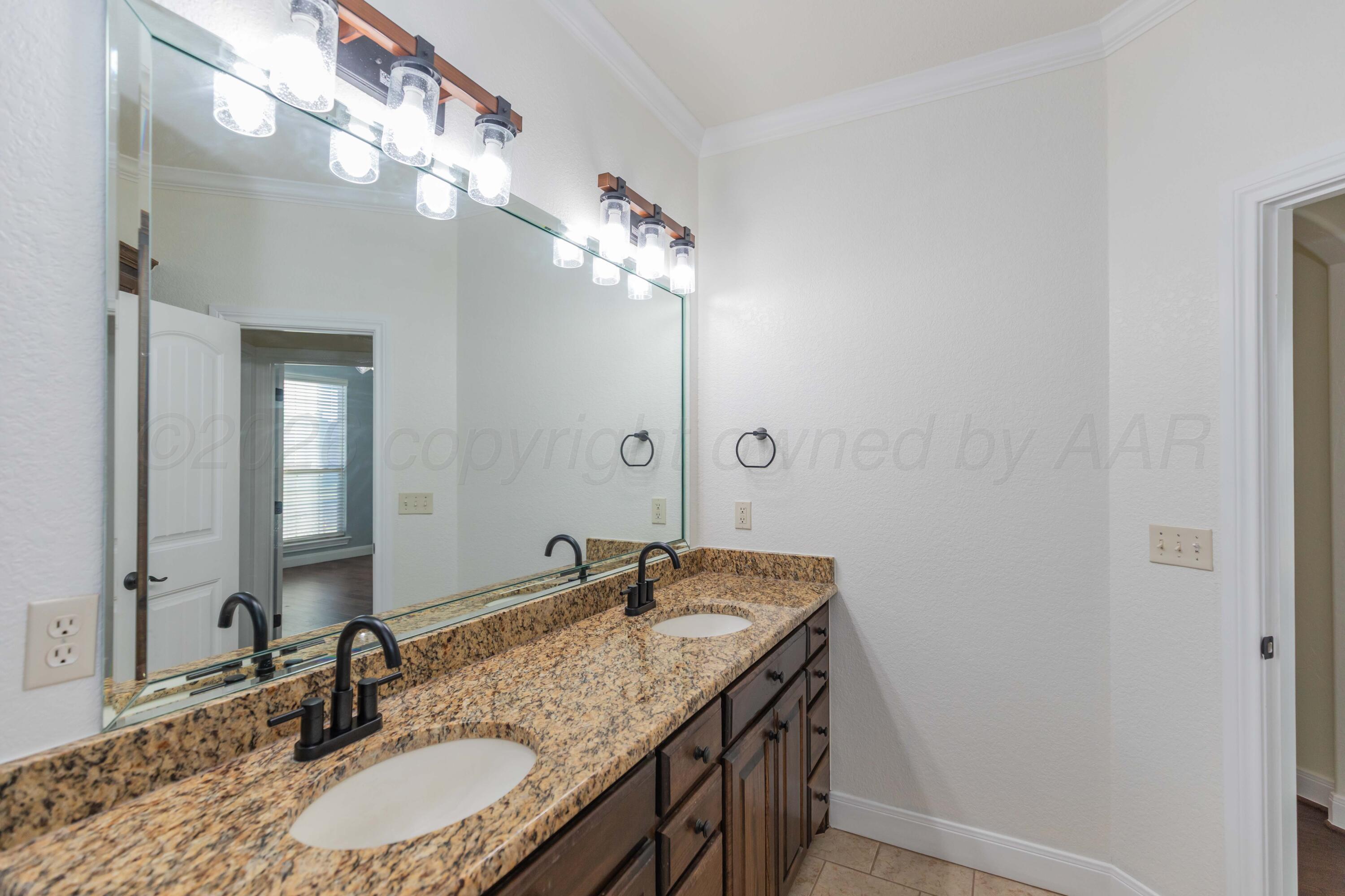 7718 Pinnacle Drive Amarillo, TX 79119 - Photo 43 of 66 a bathroom with a granite countertop sink and a mirror