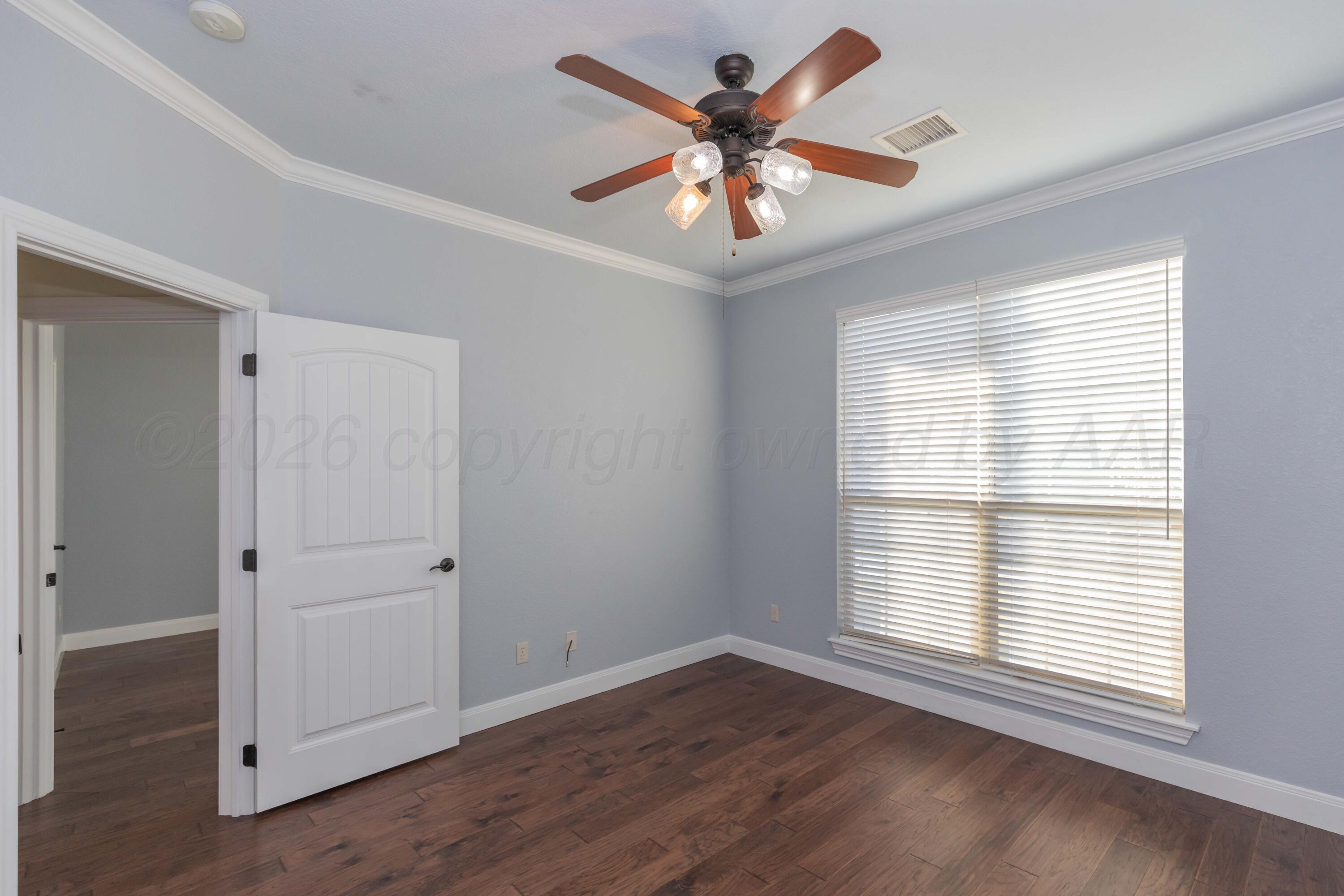 7718 Pinnacle Drive Amarillo, TX 79119 - Photo 45 of 66 a view of an empty room with wooden floor and a window