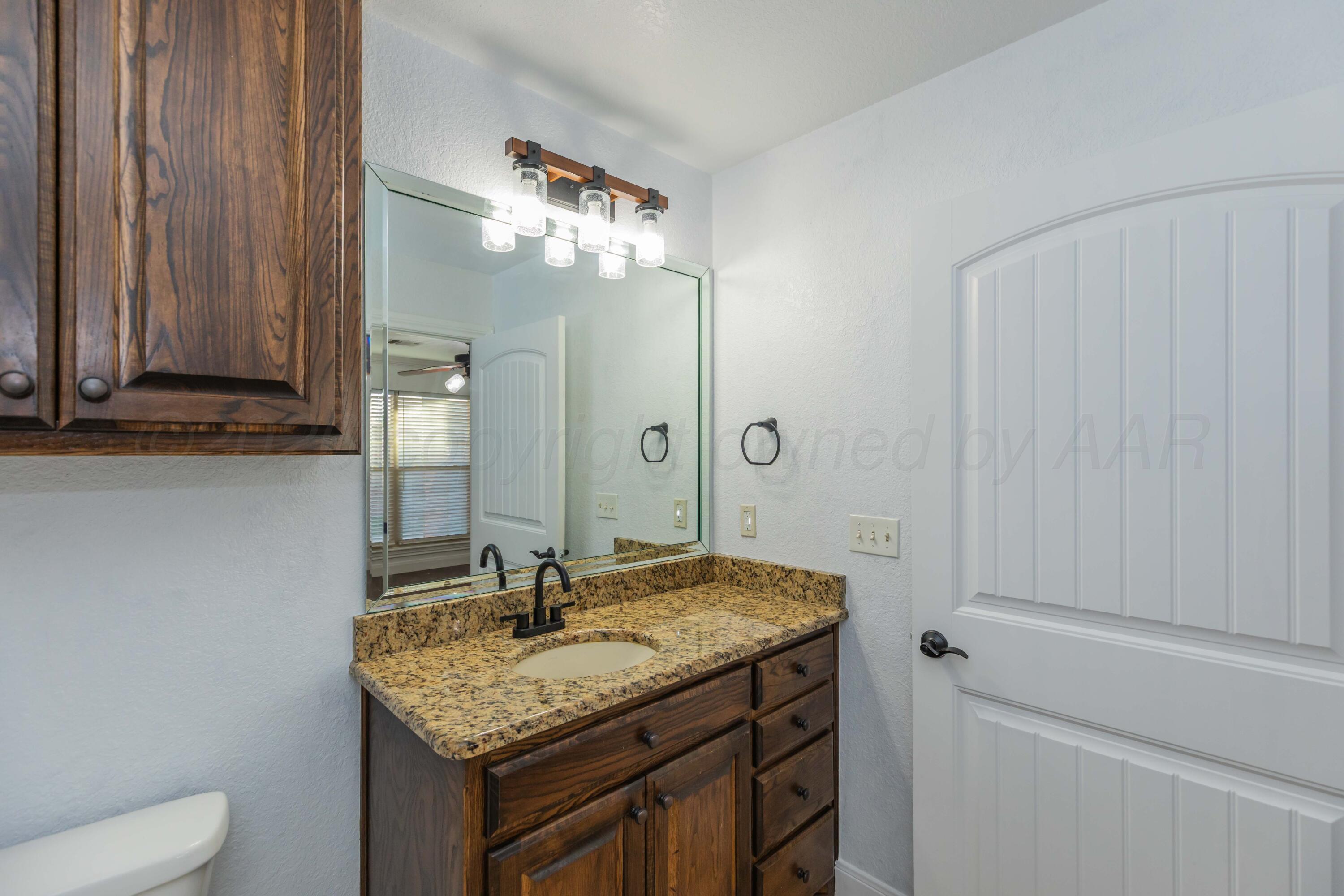 7718 Pinnacle Drive Amarillo, TX 79119 - Photo 51 of 66 a bathroom with a granite countertop sink and a mirror