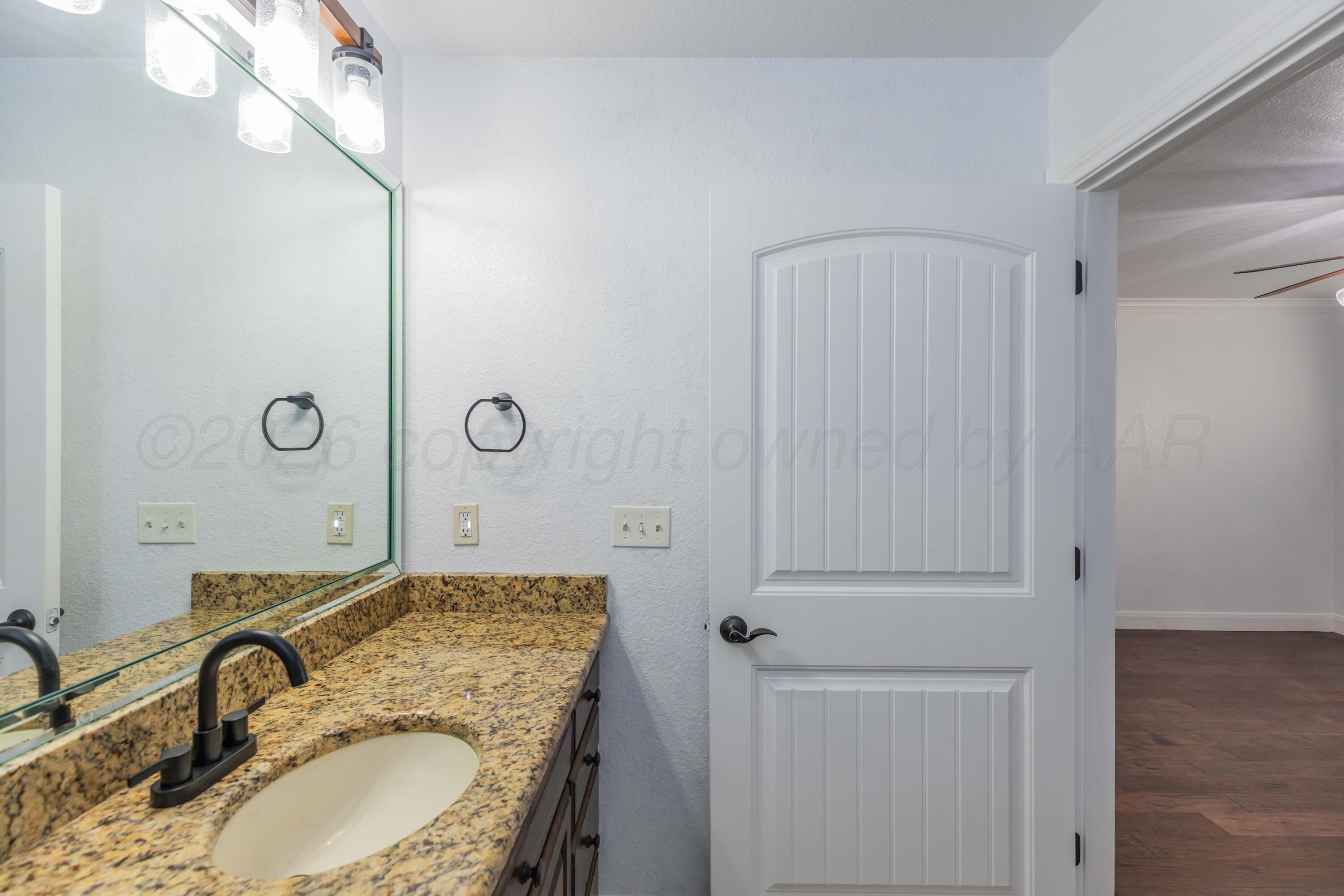 7718 Pinnacle Drive Amarillo, TX 79119 - Photo 53 of 66 a bathroom with a granite countertop sink and a mirror