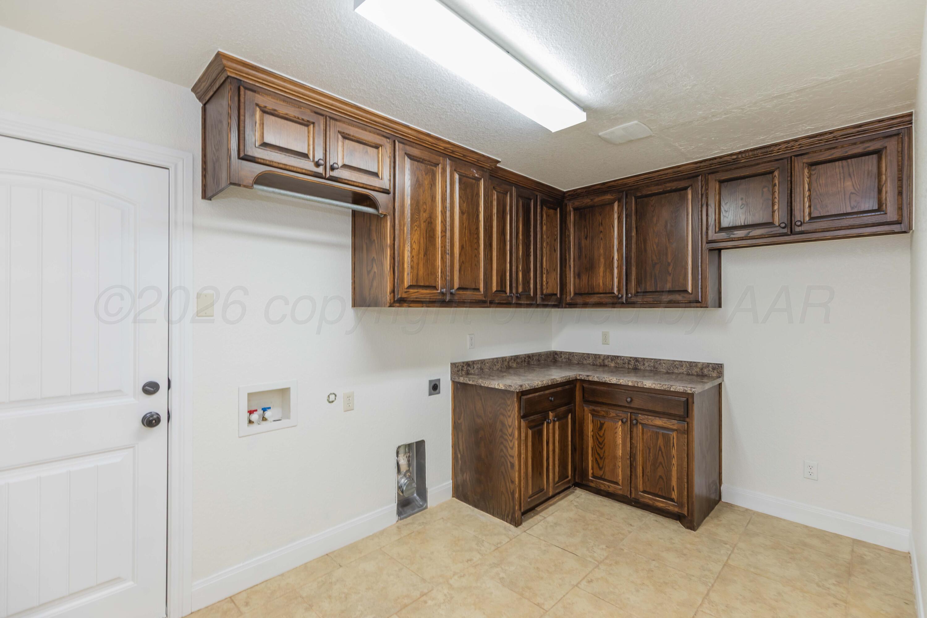 7718 Pinnacle Drive Amarillo, TX 79119 - Photo 54 of 66 a kitchen with stainless steel appliances granite countertop a refrigerator a stove and a sink with wooden cabinets
