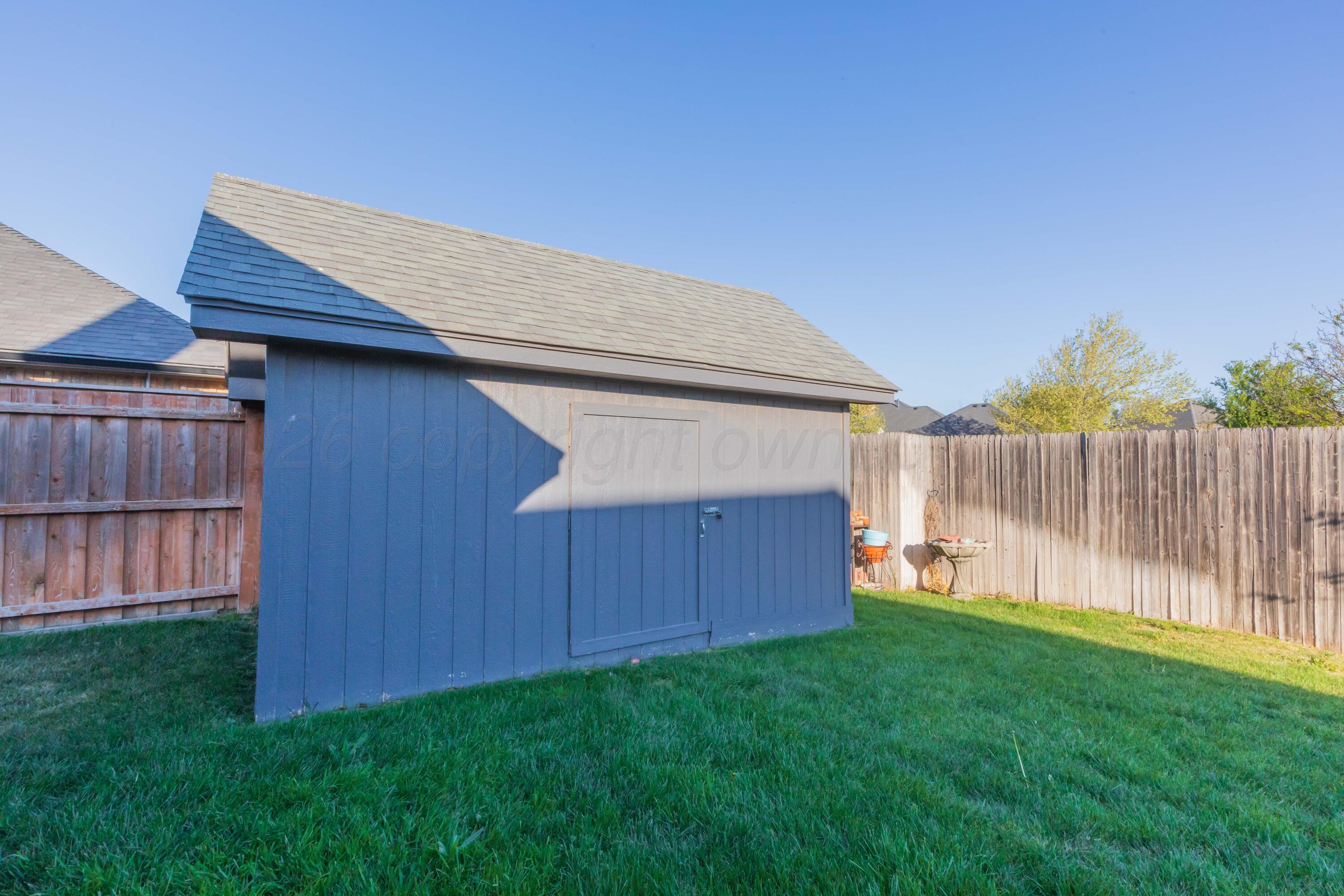 7718 Pinnacle Drive Amarillo, TX 79119 - Photo 65 of 66 a backyard of a house with lawn chairs and wooden fence