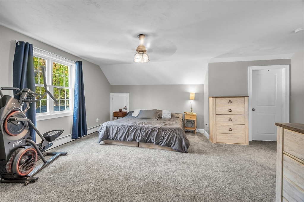 20 Main Street Ashburnham, MA 01430 - Photo 28 of 42 a spacious bedroom with a bed a table and a large window