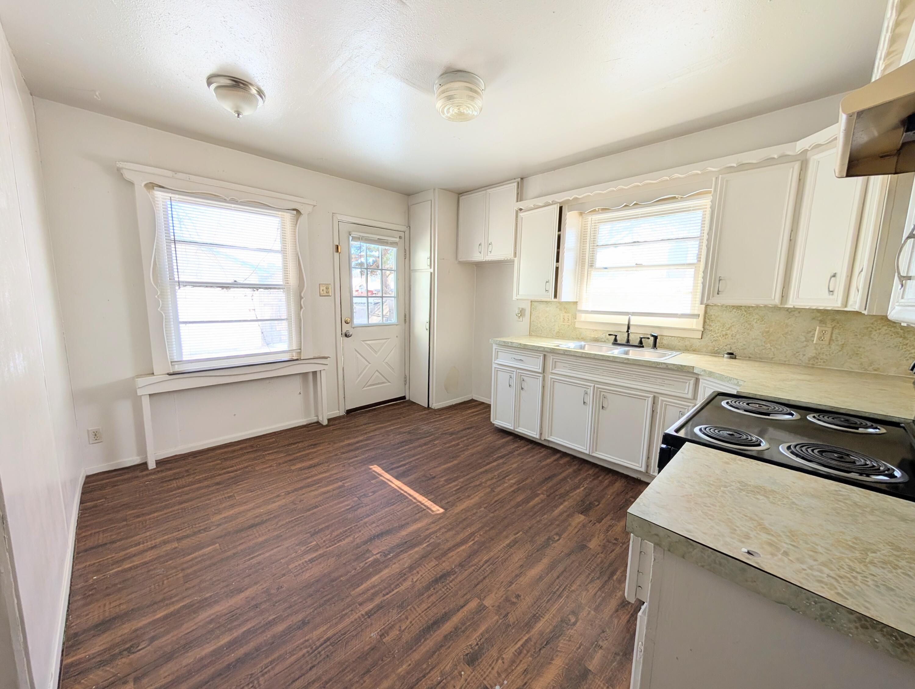 9001 Indiana Avenue, Unit C Lubbock, TX 79423 - Photo 1 of 6 a kitchen with stove cabinets and wooden floor