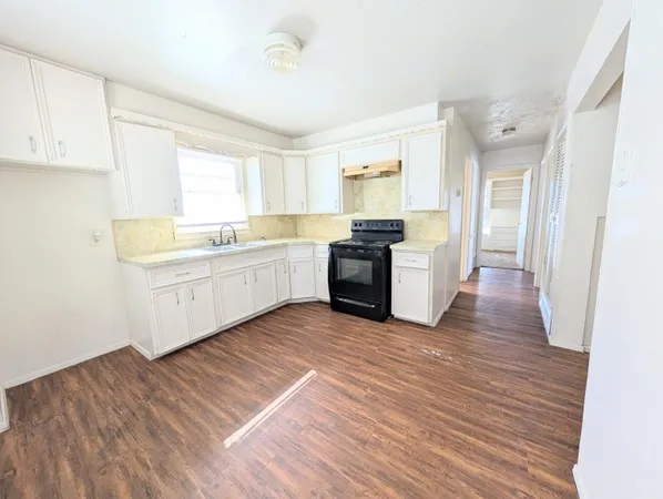 a large kitchen with wooden floors and stainless steel appliances