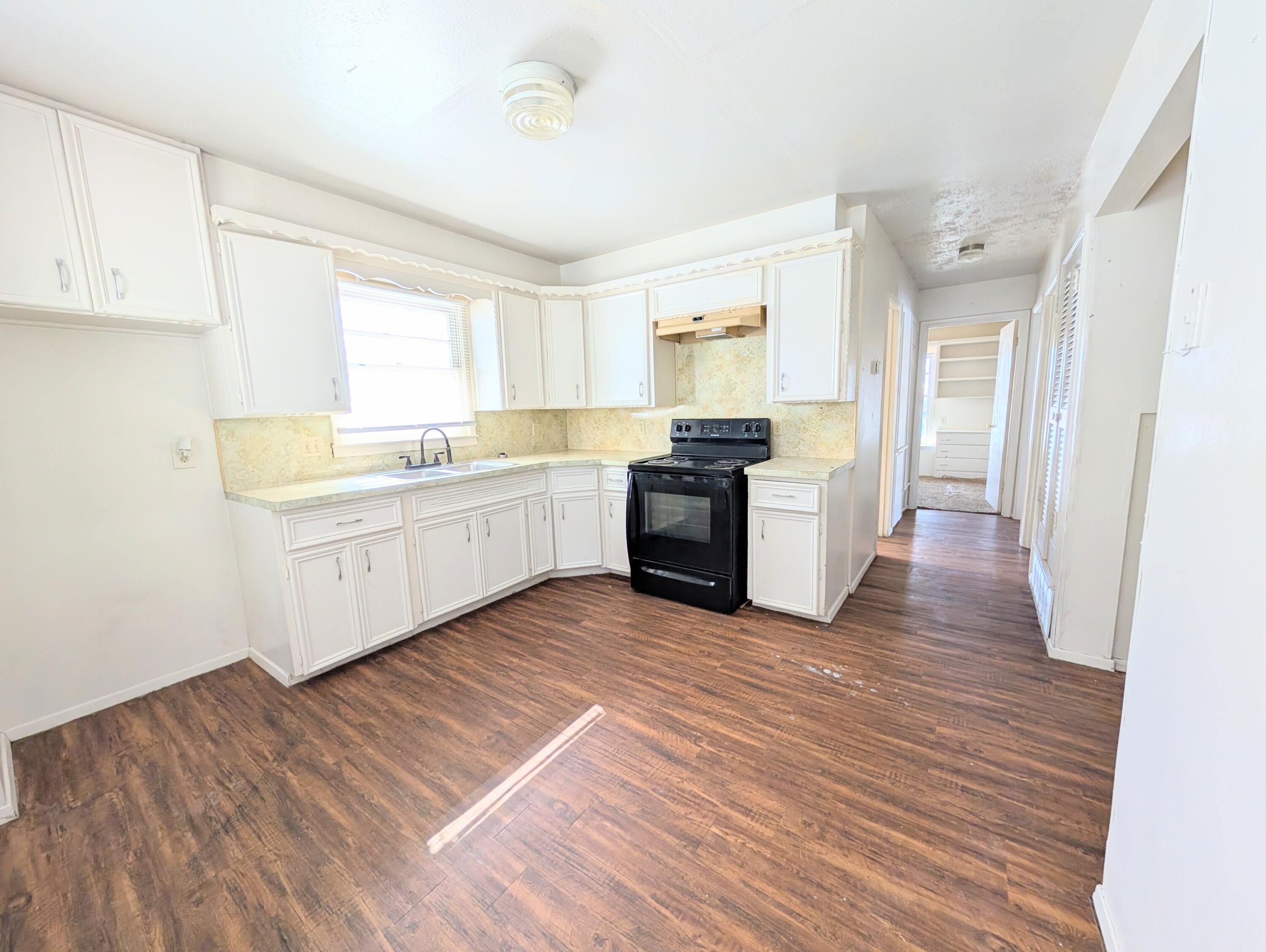 9001 Indiana Avenue, Unit C Lubbock, TX 79423 - Photo 2 of 6 a large kitchen with wooden floors and stainless steel appliances