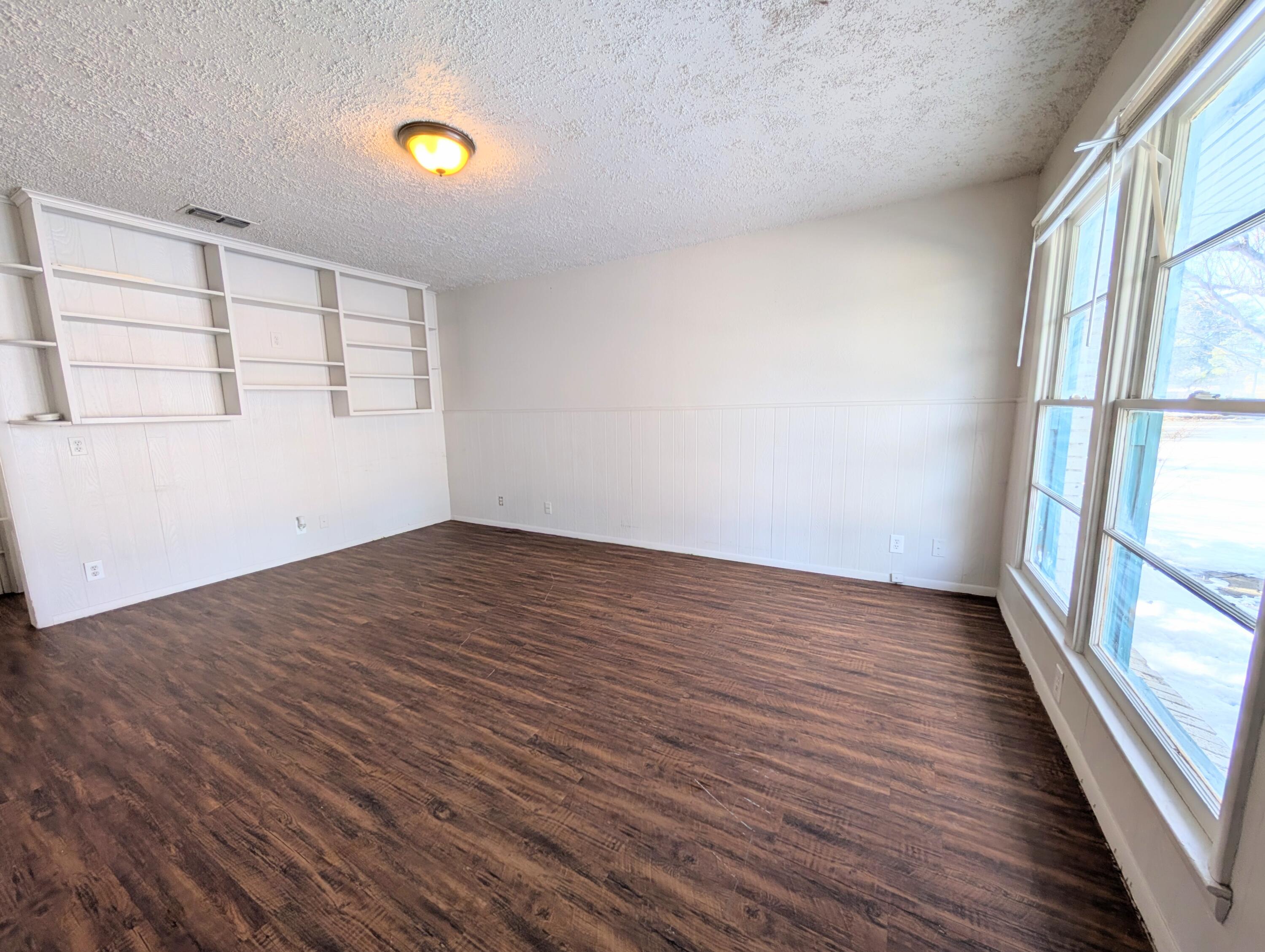 9001 Indiana Avenue, Unit C Lubbock, TX 79423 - Photo 5 of 6 wooden floor in an empty room with a window