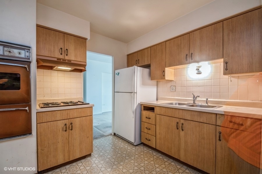 9001 West Golf Road, Unit 5I Des Plaines, IL 60016 - Photo 6 of 14 a kitchen with a sink stove and refrigerator
