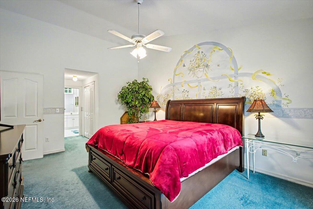 22 Farnum Lane Palm Coast, FL 32137 - Photo 15 of 17 a spacious bedroom with a bed and a chandelier