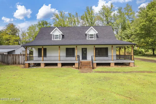a aerial view of a house with a big yard and large trees