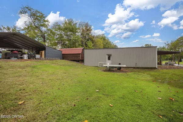 a backyard of a house with barbeque oven table and chairs