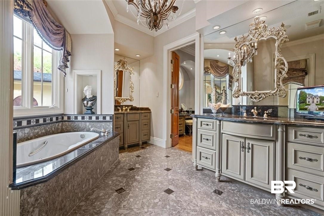 4 Chancery Court Mobile, AL 36608 - Photo 24 of 54 Bathroom featuring tiled tub, vanity, ornamental molding, and a notable chandelier