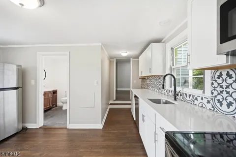 a large white kitchen with a sink and a large window