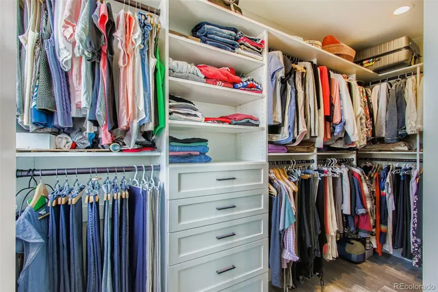 a view of walk in closet with clothes and shoes