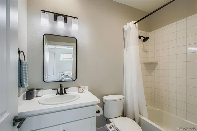 a bathroom with a toilet sink vanity shower and mirror