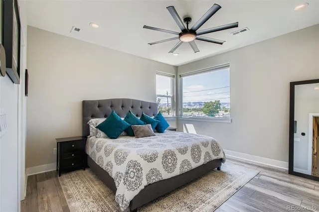 a bedroom with a large bed chandelier and a window