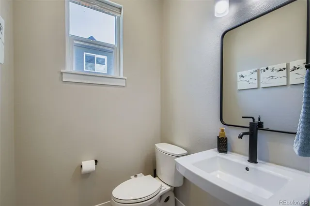 a bathroom with a sink mirror and toilet