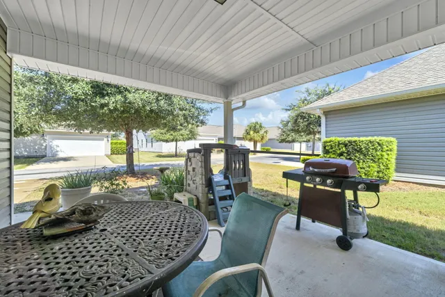 a living room with patio furniture and a garden
