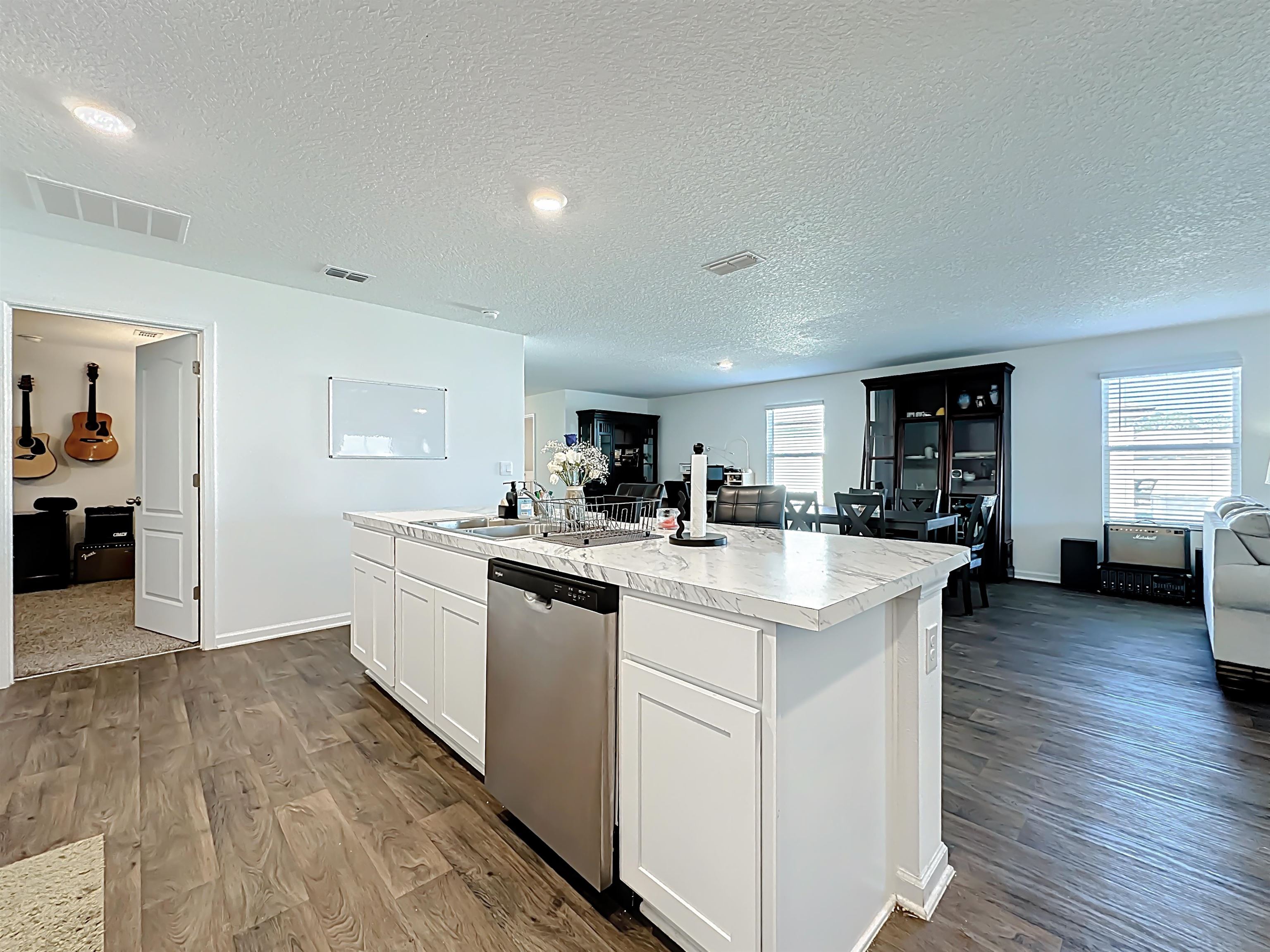 16 Encanto Way Street St. Augustine, FL 32084 - Photo 55 of 56 Kitchen featuring white cabinetry, open floor plan, light countertops, stainless steel dishwasher, and dark wood finished floors