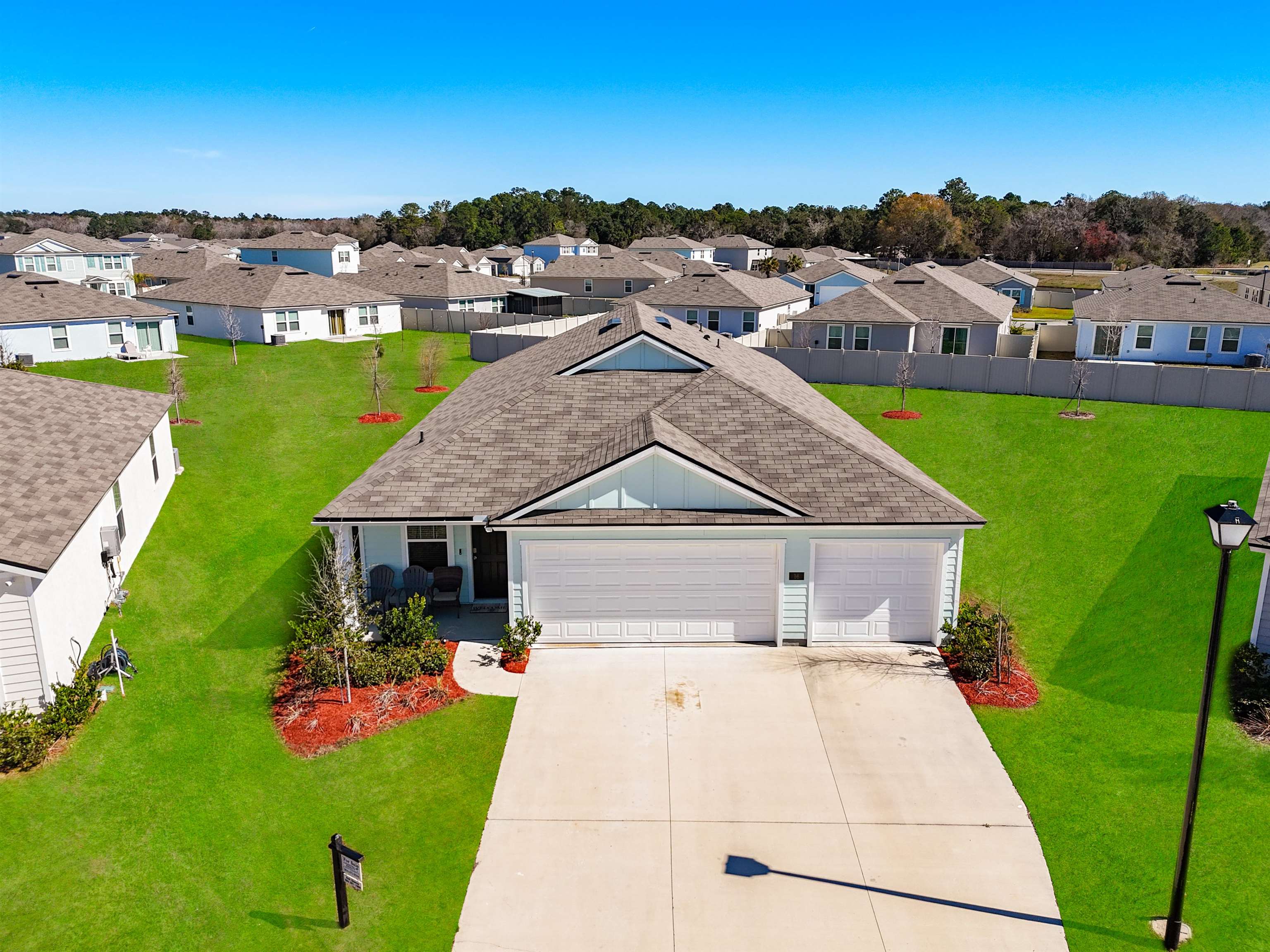 16 Encanto Way Street St. Augustine, FL 32084 - Photo 2 of 56 View of front of property with roof with shingles, an attached garage, concrete driveway, a residential view, and a front yard