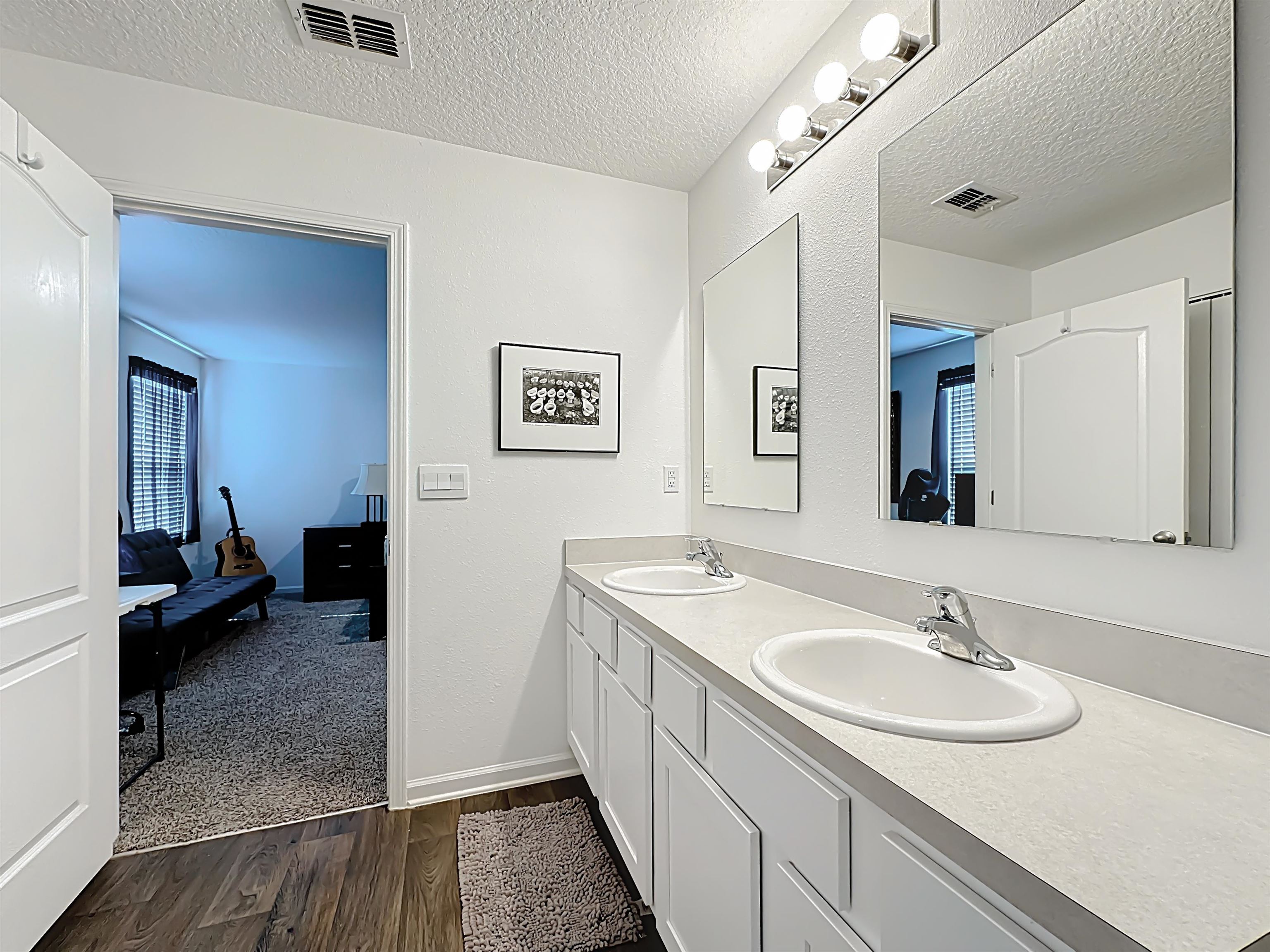 16 Encanto Way Street St. Augustine, FL 32084 - Photo 25 of 56 Full bathroom with a textured ceiling, double vanity, dark wood-type flooring, plenty of natural light, and connected bathroom