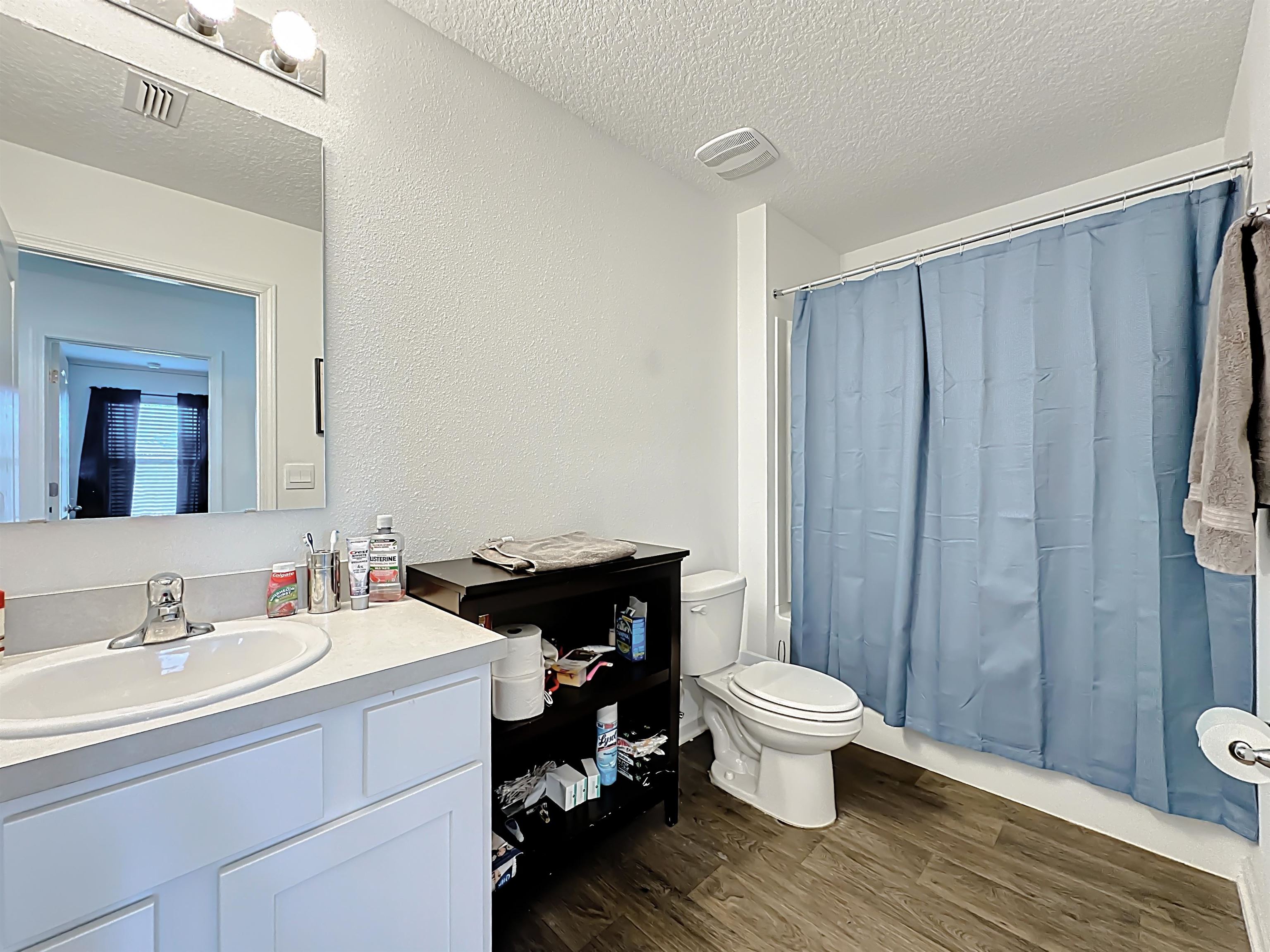 16 Encanto Way Street St. Augustine, FL 32084 - Photo 28 of 56 Full bath featuring vanity, a textured ceiling, dark wood-style flooring, shower / bath combo with shower curtain, and a textured wall