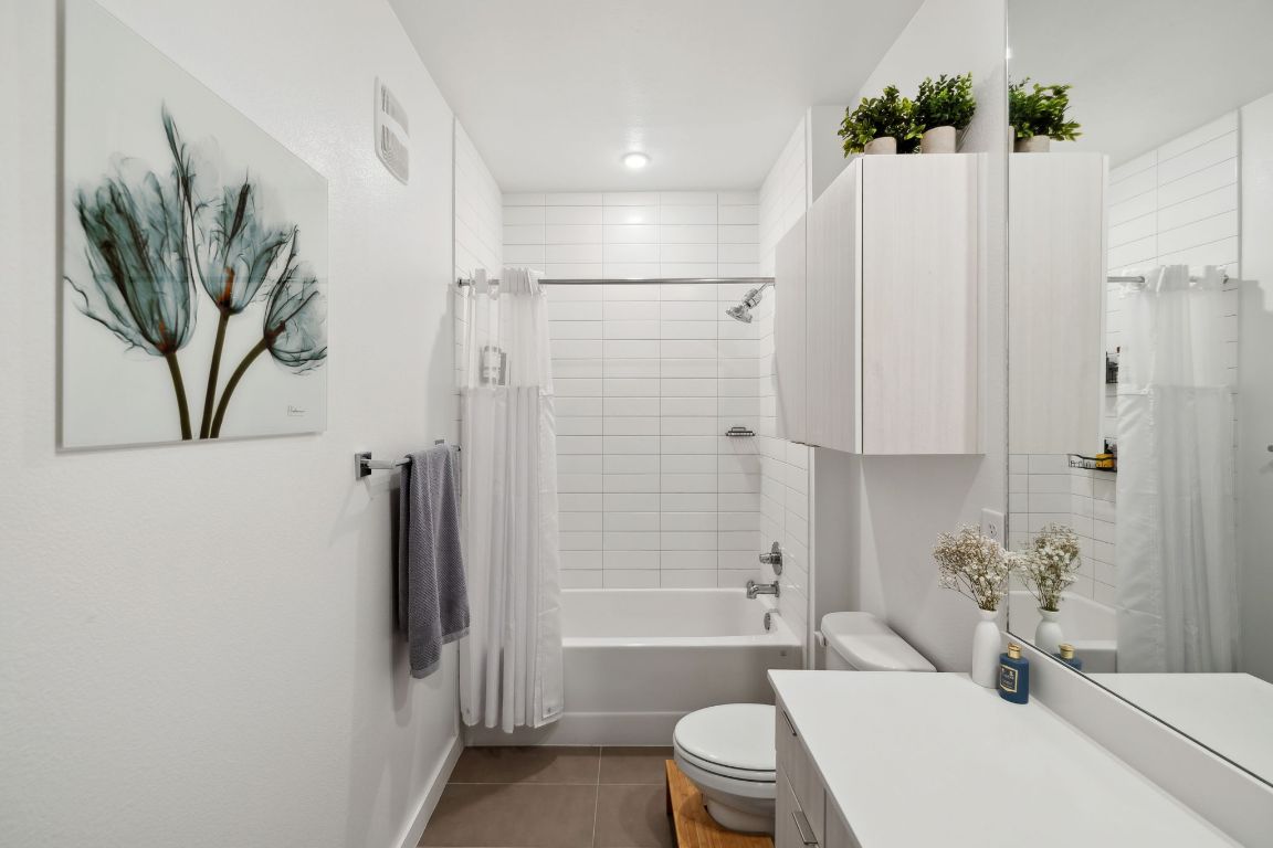 4802 South Congress Avenue, Unit 215 Austin, TX 78745 - Photo 11 of 32 a bathroom with a sink a toilet a tub and shower