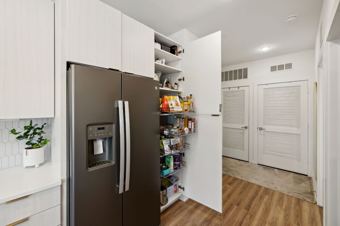 4802 South Congress Avenue, Unit 215 Austin, TX 78745 - Photo 14 of 32 a kitchen with stainless steel appliances a refrigerator and a hard wood floor
