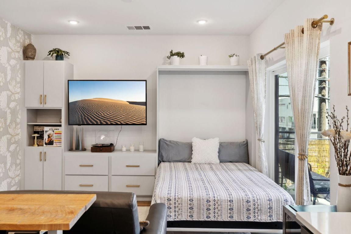 4802 South Congress Avenue, Unit 215 Austin, TX 78745 - Photo 19 of 32 a bedroom with a bed and a flat screen tv