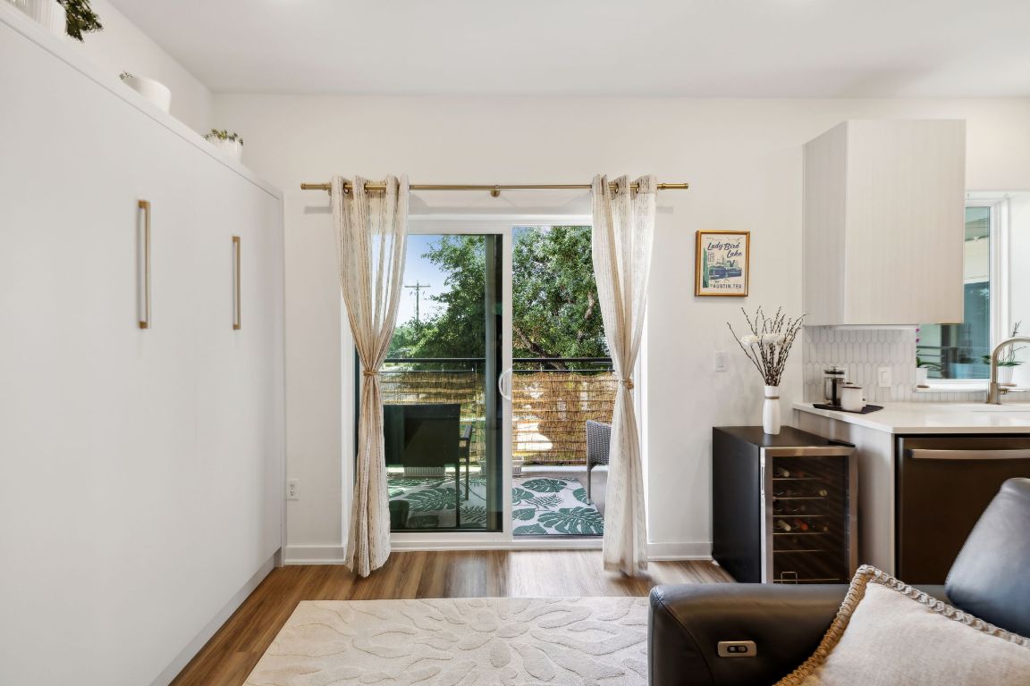 4802 South Congress Avenue, Unit 215 Austin, TX 78745 - Photo 20 of 32 a living room with furniture a large window and a wooden floor
