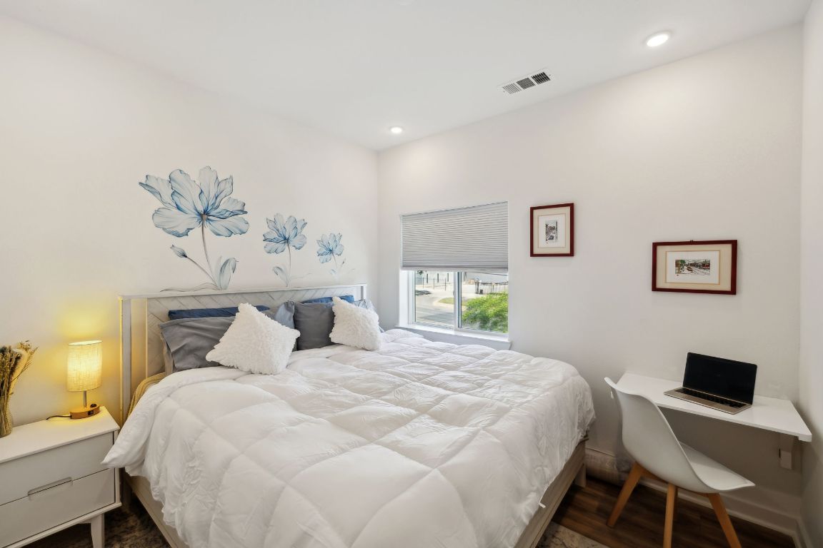 4802 South Congress Avenue, Unit 215 Austin, TX 78745 - Photo 9 of 32 a bedroom with a bed and a chandelier