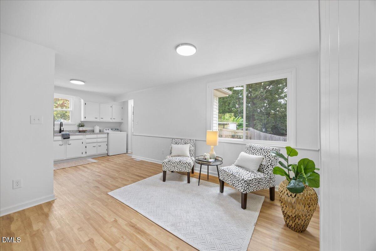 3437 Apache Drive Raleigh, NC 27609 - Photo 14 of 40 LVP flooring, white wall paneling, and a large window with natural light