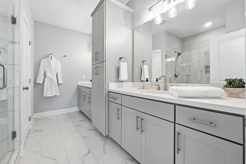 a spacious bathroom with a double vanity sink a mirror and a shower