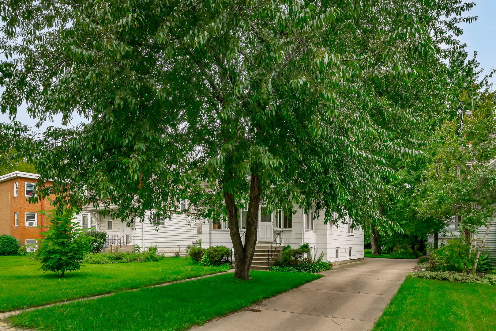 110 Pine Street Elmhurst, IL 60126 - Photo 4 of 7 a view of a white house with a big yard and large trees