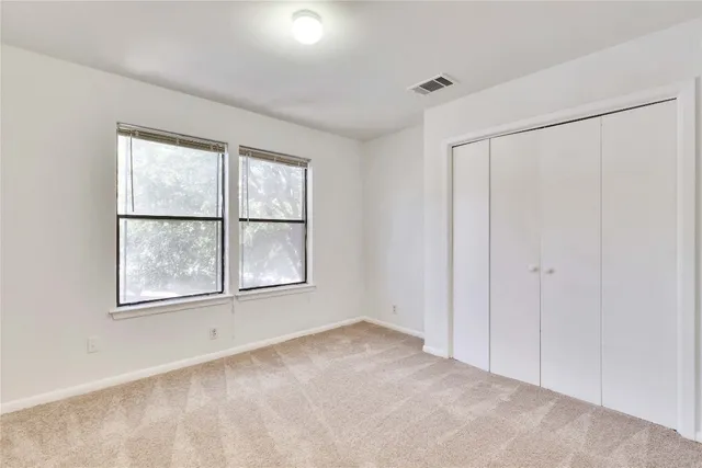 an empty room with windows and closet