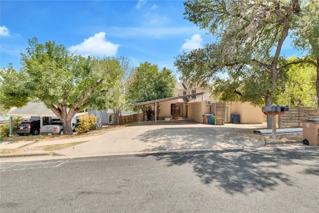 a front view of a house with a yard and trees