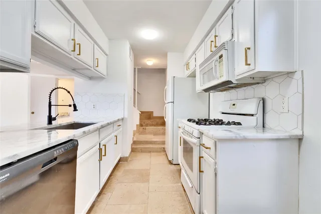 a kitchen with stainless steel appliances granite countertop a sink and cabinets