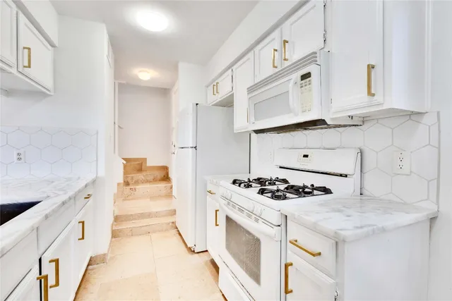 a kitchen with granite countertop cabinets and stove