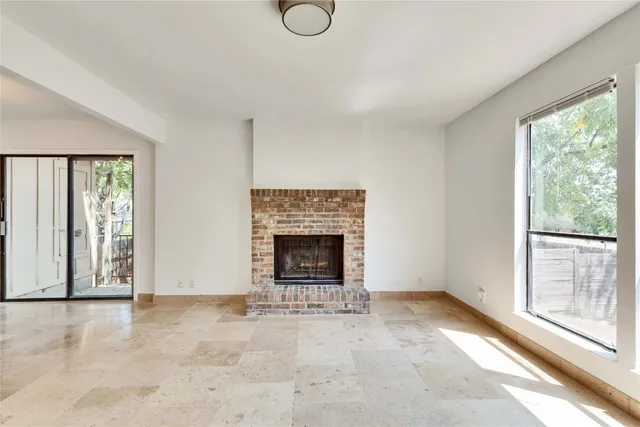 a view of an empty room with a window and fireplace