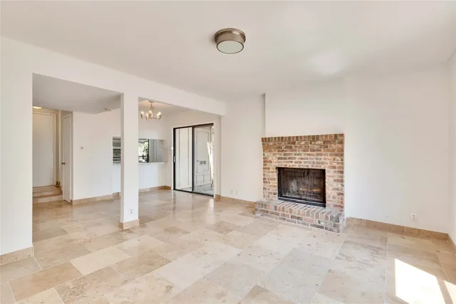 an empty room with fireplace and a window