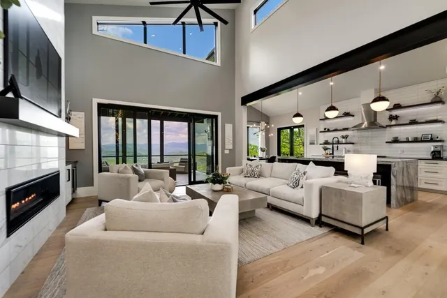a living room with furniture fireplace and a large window