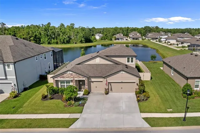 a aerial view of a house with a yard and lake view