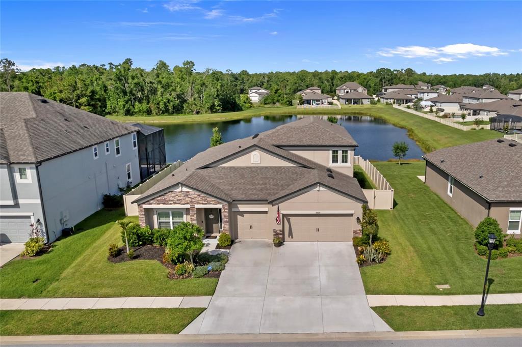 a aerial view of a house with a yard and lake view