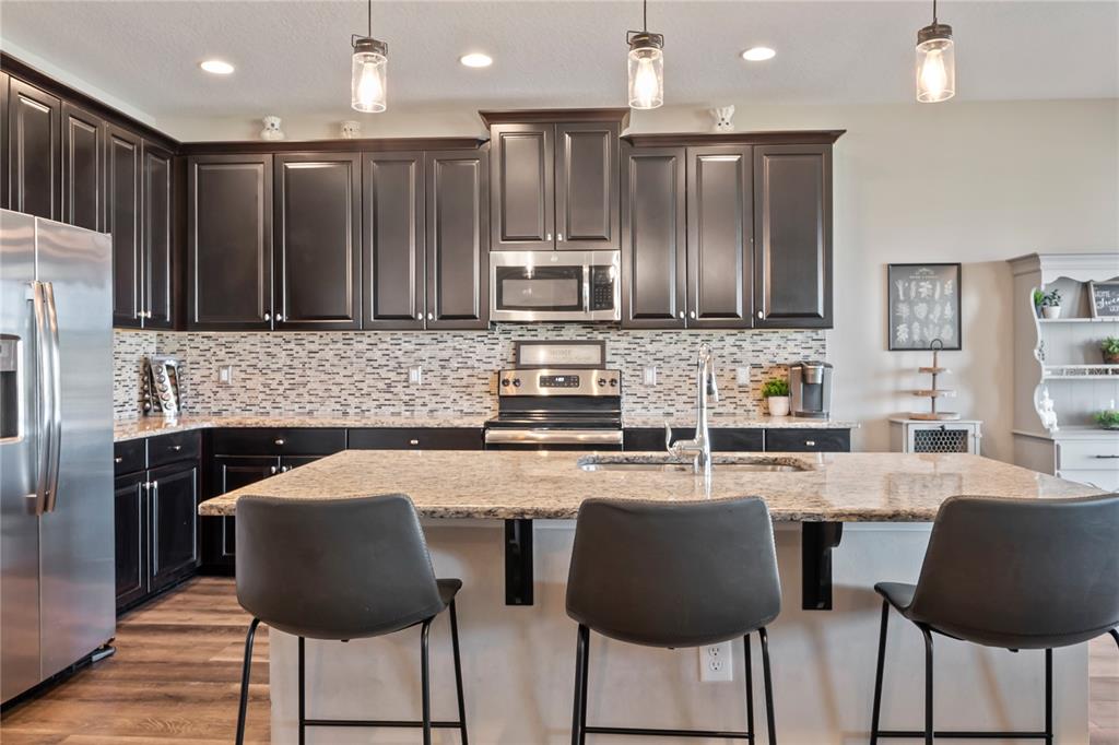 18428 Malinche Loop Spring Hill, FL 34610 - Photo 11 of 62 a kitchen with stainless steel appliances granite countertop a stove top oven a sink and a refrigerator