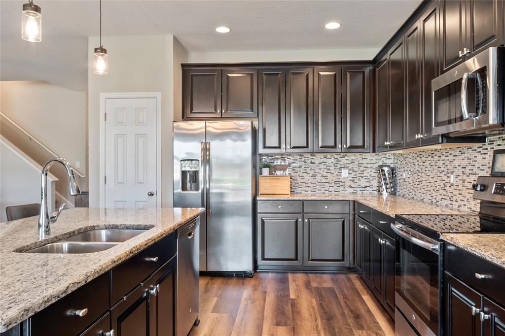 18428 Malinche Loop Spring Hill, FL 34610 - Photo 12 of 62 a kitchen with stainless steel appliances granite countertop a sink stove and refrigerator