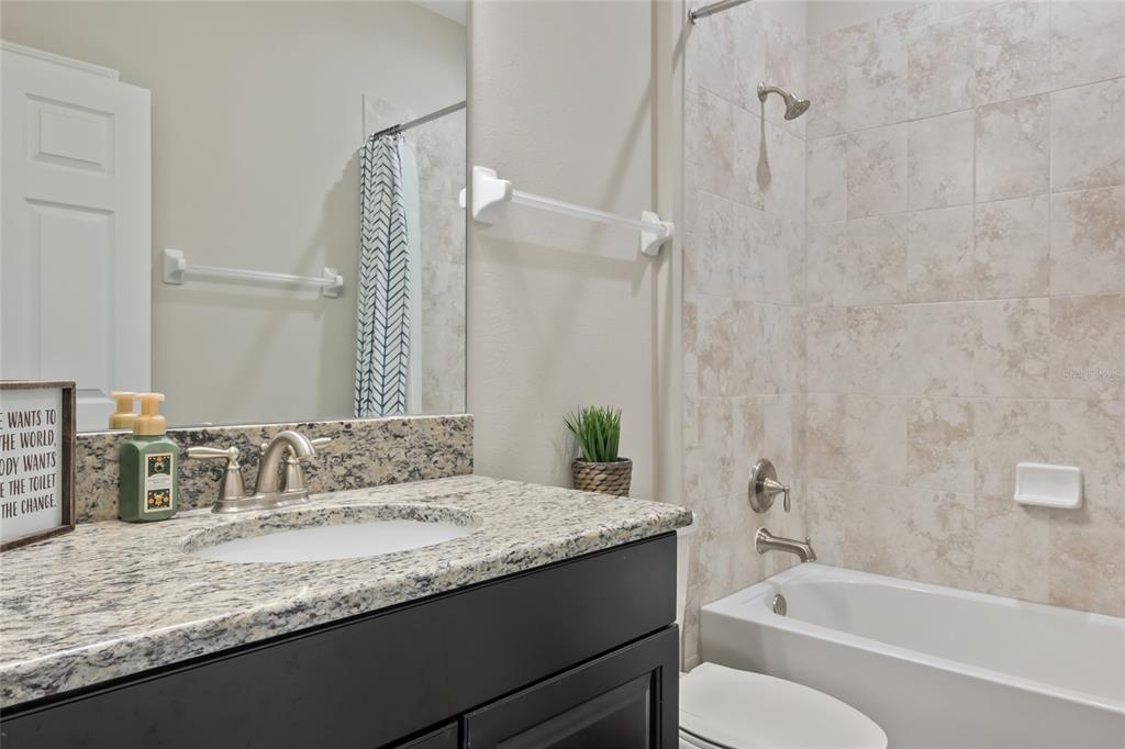 18428 Malinche Loop Spring Hill, FL 34610 - Photo 28 of 62 a bathroom with a granite countertop sink a toilet and bathtub