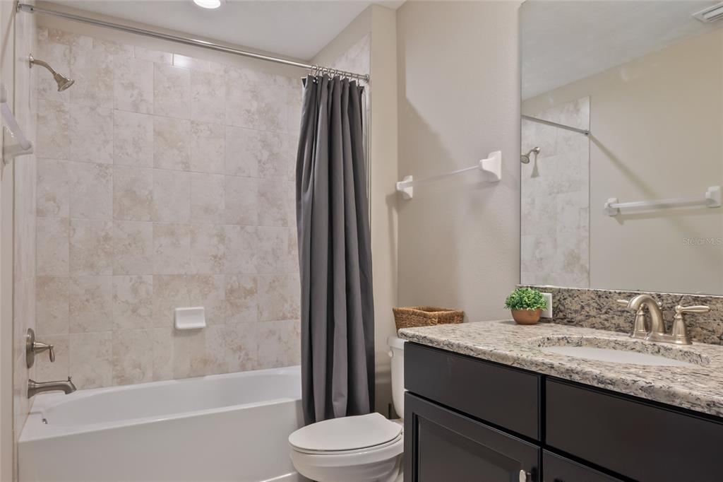 18428 Malinche Loop Spring Hill, FL 34610 - Photo 33 of 62 a bathroom with a granite countertop sink toilet and shower