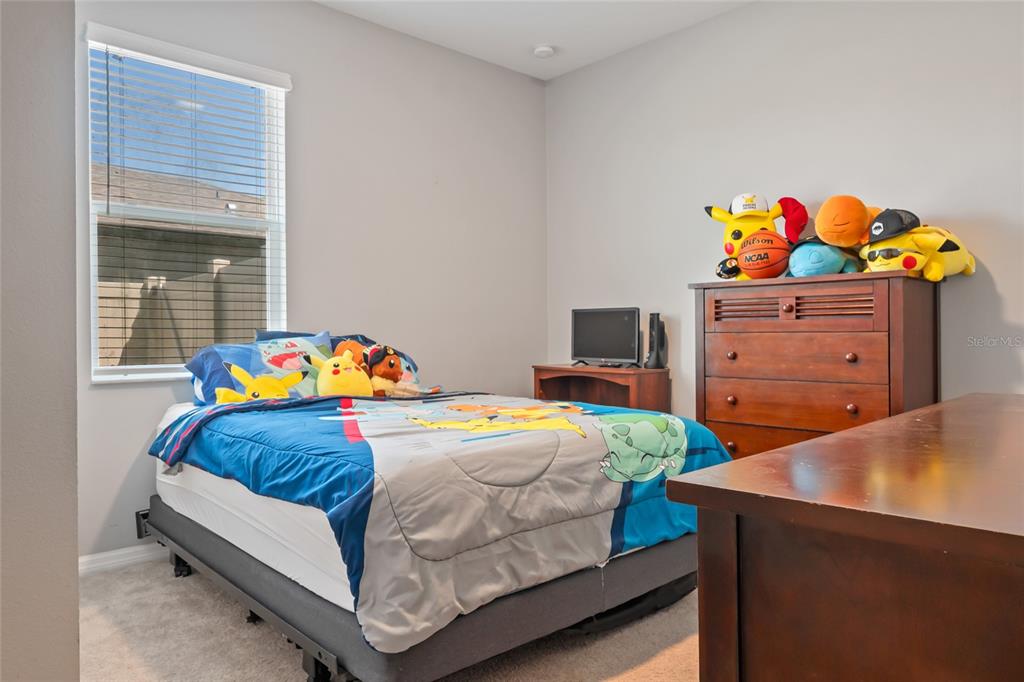 18428 Malinche Loop Spring Hill, FL 34610 - Photo 34 of 62 a bedroom with a bed and a dresser