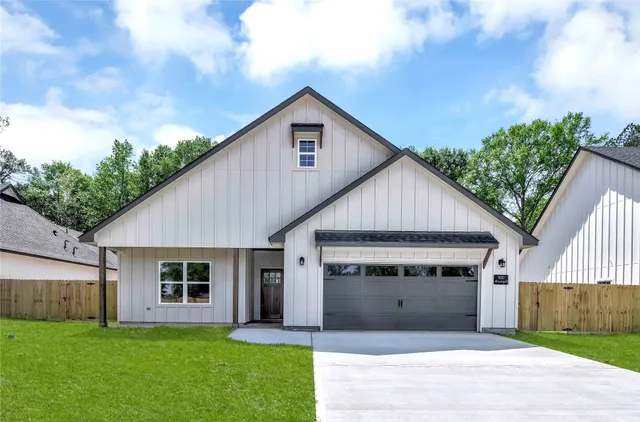 a view of a house with a yard and potted plants