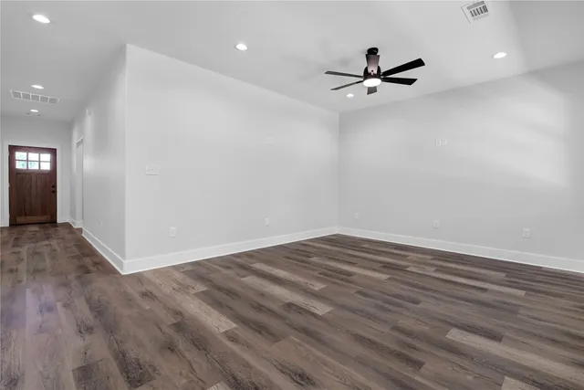 a view of empty room with wooden floor